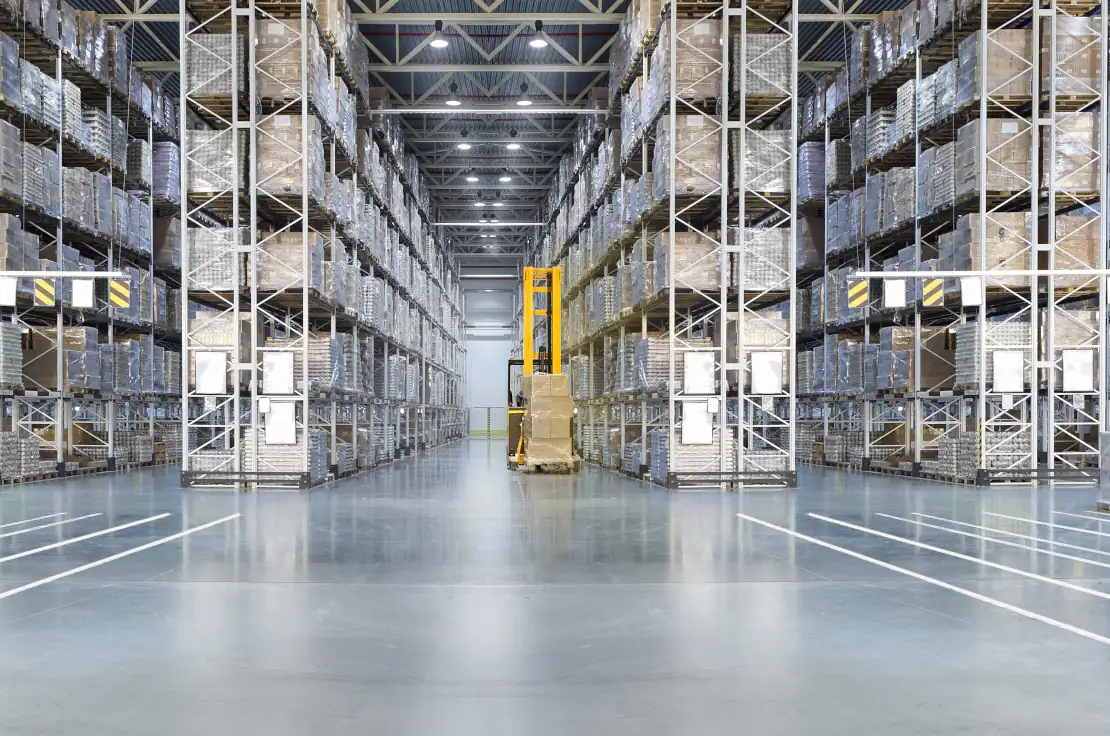 Huge distribution warehouse with high shelves and loaders. Bottom view.